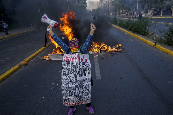 A Mapuche Indigenous woman protests against then-Chilean President Sebastian Pinera in Santiago, Chile, Nov. 4, 2021 (AP photo by Esteban Felix).