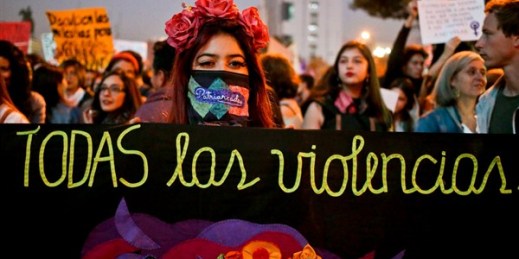 A woman holds a cloth with text that reads in Spanish ‘All violence’ during a march called by feminist activists, Santiago, Chile, May 11, 2018 (AP photo by Esteban Felix).