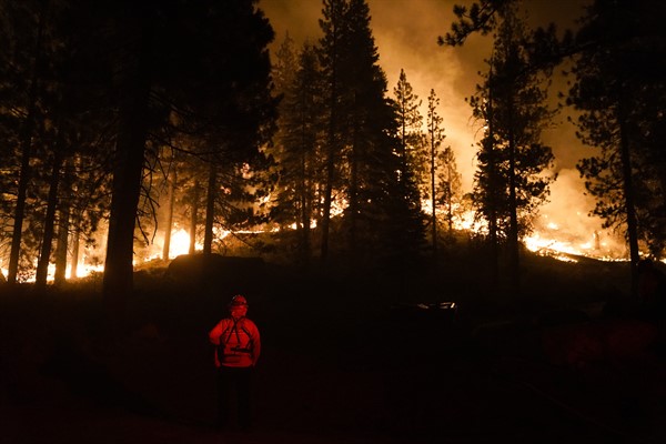 A firefighter monitors the Caldor Fire burning near structures in South Lake Tahoe, Calif., Aug. 30, 2021 (AP photo by Jae C. Hong).