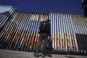 A migrant waits on the Mexican side of the border in Tijuana, Mexico, Jan. 26, 2022 (AP photo by Marco Ugarte).