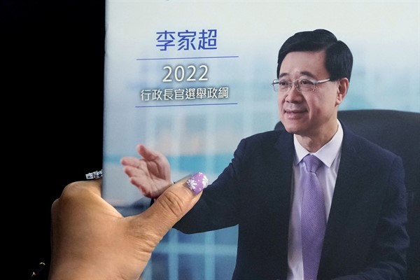 A supporter of John Lee, Hong Kong’s chief executive-elect, holds a copy of Lee’s election manifesto during a 2022 chief executive electoral campaign in Hong Kong, April 29, 2022 (AP photo by Kin Cheung).
