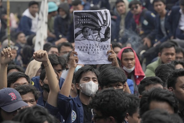 A student holds a poster portraying President Joko Widodo during a rally against postponing the 2024 presidential election, Jakarta, Indonesia, April 21, 2022 (AP photo by Tatan Syuflana).