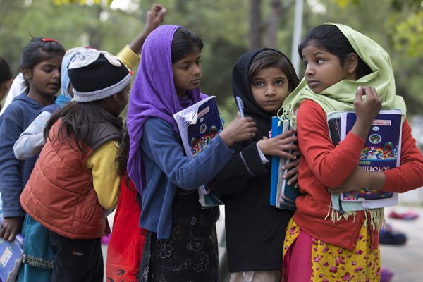 Girls from poor localities wait their turn to show school work to teacher, at a makeshift school in a city park in Islamabad, Pakistan, Nov. 13, 2018 (AP photo by B.K. Bangash).