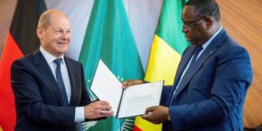 German Chancellor Olaf Scholz hands over an invitation to the G-7 Summit in Elmau to Senegalese President Macky Sall, before a meeting at the Presidential Palace in Dakar, Senegal, May 22, 2022 (DPA photo by Michael Kappeler via AP Images).
