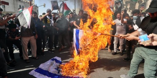 Protesters chant slogans while burning representations of Israeli flags during a demonstration in Tahrir Square, Baghdad, Iraq, May 15, 2021 (AP photo by Khalid Mohammed).