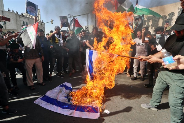 Protesters chant slogans while burning representations of Israeli flags during a demonstration in Tahrir Square, Baghdad, Iraq, May 15, 2021 (AP photo by Khalid Mohammed).