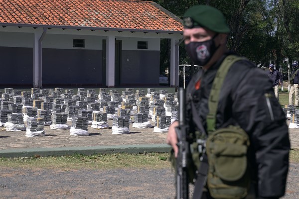 Police stand guard over seized cocaine that is displayed to the press at the Special Forces Police headquarters in Asuncion, Paraguay, July 28, 2021 (AP photo by Jorge Saenz).