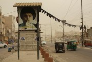 Motorists in Iraq drive past a poster bearing the image of Shiite cleric Muqtada al-Sadr, June 13, 2022.