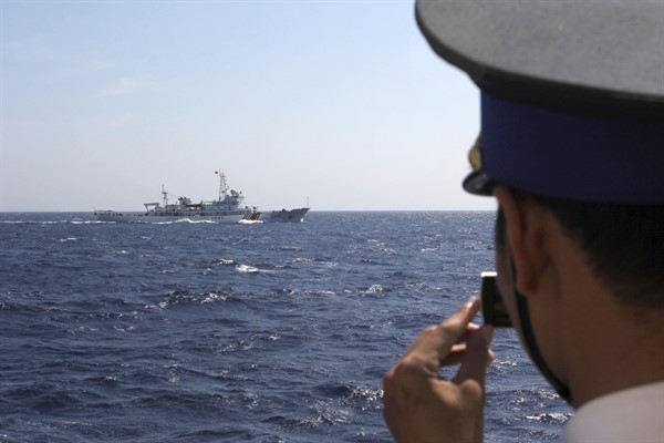 An officer on board a Vietnamese coast guard vessel films a Chinese coast guard vessel sailing in the waters claimed by both countries in the South China Sea, May 15, 2014 (AP photo by Hau Dinh).
