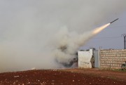 Turkish soldiers fire a missile at a Syrian government-held position