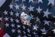 Abortion rights activists are seen through a hole in an American flag as they protest outside the Supreme Court in Washington, June 25, 2022 (AP photo by Jose Luis Magana).
