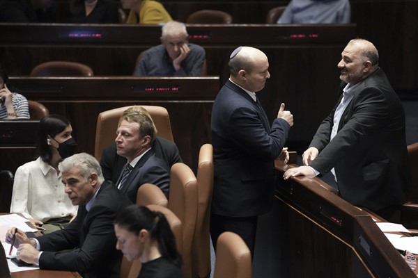Then-Israeli Prime Minister Naftali Bennett, center, speaks with lawmaker Mansour Abbas ahead of the vote to dissolve the Knesset, in Jerusalem, June 30, 2022 (AP photo by Ariel Schalit).