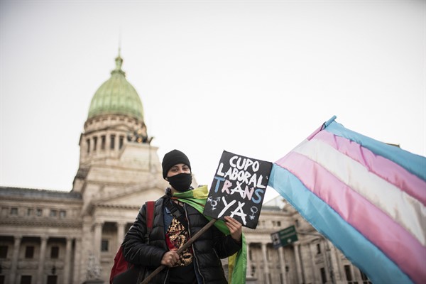 A demonstrator holds a placard in favor of a work quota for transvestites and transgender people outside Congress ahead of the Senate vote that approved the law (Sipa photo by Manuel Cortina via AP Images).