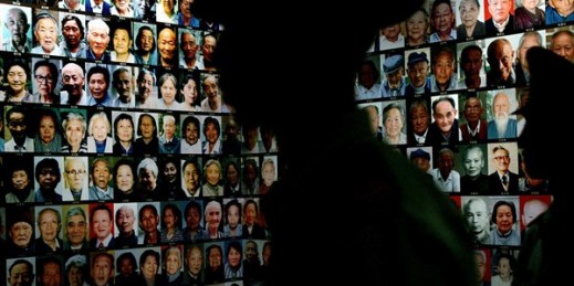 Chinese soldiers look at photographs of survivors of the Nanjing Massacre at the National Museum of China in Beijing, Aug. 12, 2005 (AP photo by Elizabeth Dalziel).