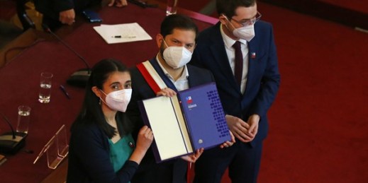 Chilean President Gabriel Boric, center, holds the final draft of country’s new constitution, alongside Maria Elisa Quinteros and Gaspar Dominguez, members of the Constitutional Convention, in Santiago, Chile, July 4, 2022 (AP photo by Luis Hidalgo).