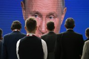 Participants gather near a screen showing a speech by Russian President Vladimir Putin during a plenary session of the 25th St. Petersburg International Economic Forum in Saint Petersburg, Russia, June 17, 2017 (Sputnik photo by Grigory Sysoev).