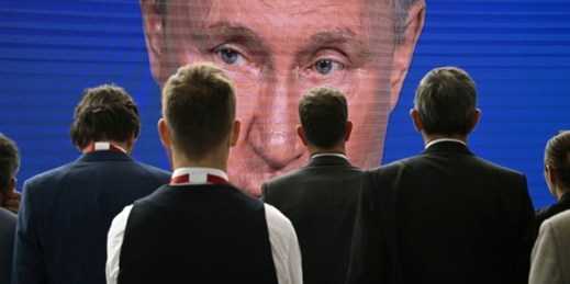 Participants gather near a screen showing a speech by Russian President Vladimir Putin during a plenary session of the 25th St. Petersburg International Economic Forum in Saint Petersburg, Russia, June 17, 2017 (Sputnik photo by Grigory Sysoev).