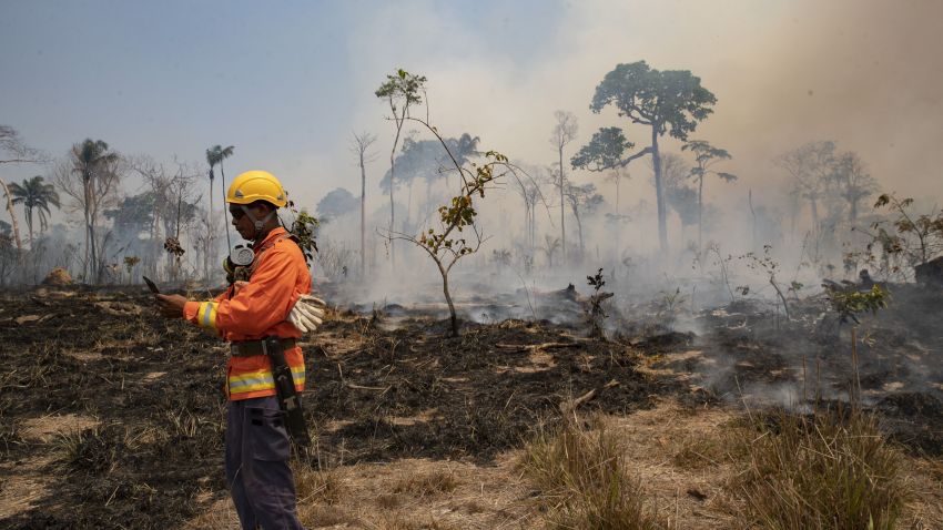 A firefighter checks his GPS device as fire consumes land deforested by cattle farmers near Novo Progresso, Para state, Brazil.