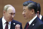 Russian President Vladimir Putin gestures while speaking to Chinese President Xi Jinping.