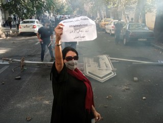 A woman protests in Iran after the death of Mahsa Amini