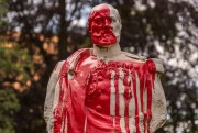 A statue of 19th-century Belgian soldier covered in red paint.