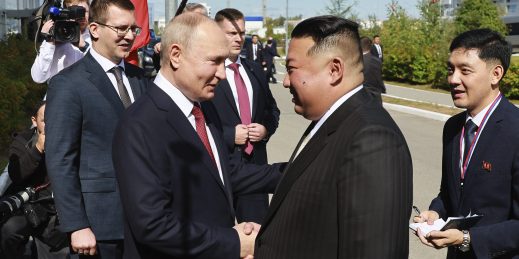 Russian President Vladimir Putin and North Korea's leader Kim Jong Un shake hands.