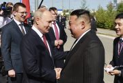 Russian President Vladimir Putin and North Korea's leader Kim Jong Un shake hands.