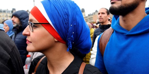 A woman wearing a headscarf in the colors of the French flag
