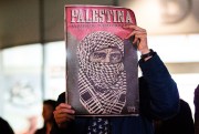 A demonstrator holds up a sign reading, “Palestine,” at a rally outside the Israeli Embassy in Bogota