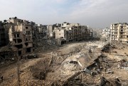 People walk through mounds of rubble that used to be high-rise apartment buildings in Aleppo, Syria.