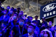 Attendees watch a presentation by automaker Geely at the Beijing International Automotive Exhibition