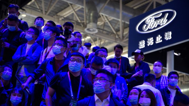 Attendees watch a presentation by automaker Geely at the Beijing International Automotive Exhibition