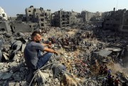 A man sits on rubble in the Gaza strip.