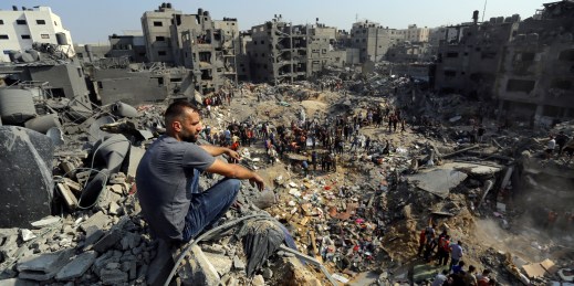 A man sits on rubble in the Gaza strip.