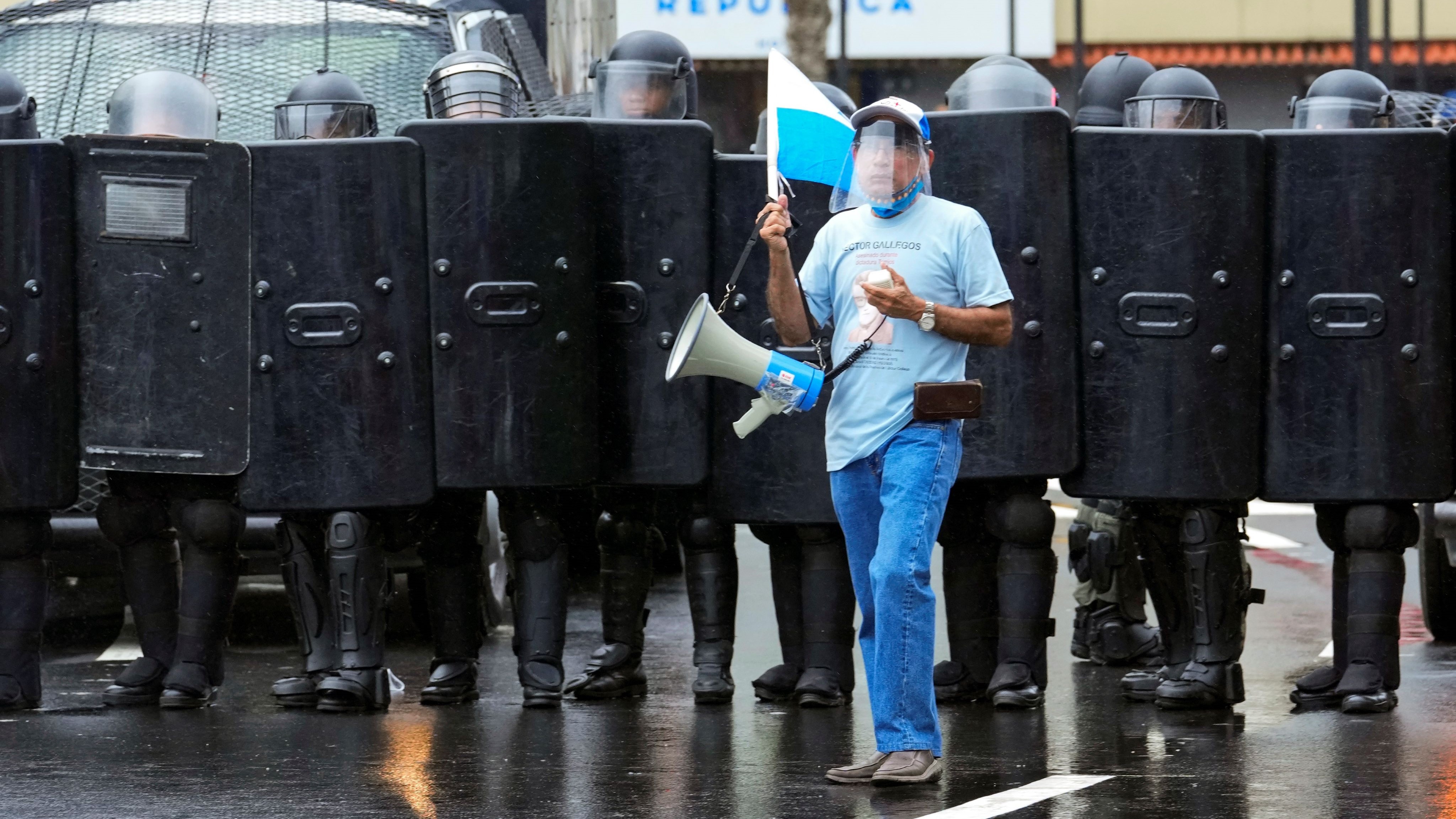 巴拿马城，一名示威者站在警察面前。