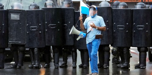 A demonstrator stands in front of police in Panama City.