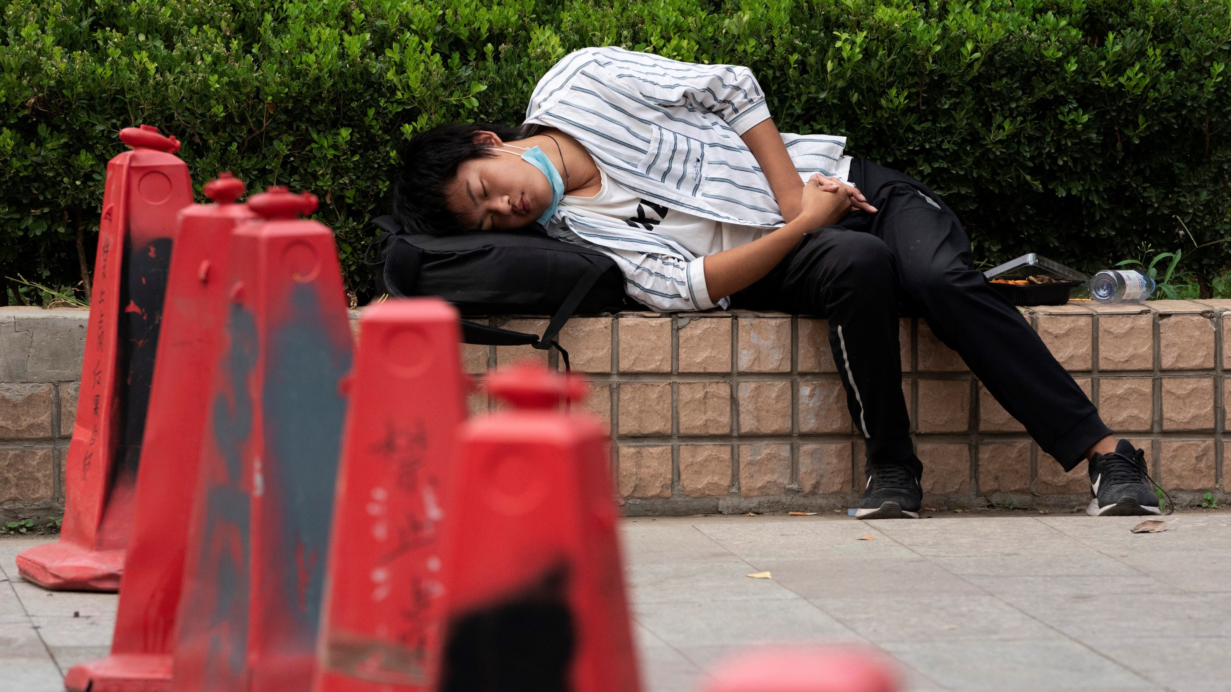 北京の路上で昼寝をする男性。 中国、2020年9月14日。