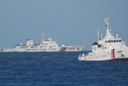A Chinese coast guard vessel passes by a Philippine coast guard ship.