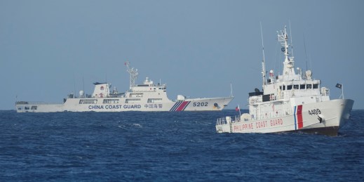 A Chinese coast guard vessel passes by a Philippine coast guard ship.
