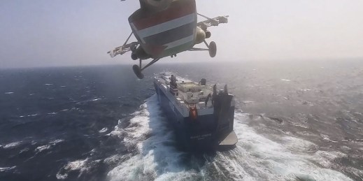 A Houthi forces helicopter approaches a cargo ship in the Red Sea.