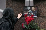 A woman touches a photo of Alexei Navalny.