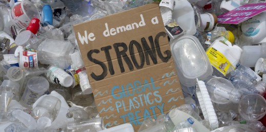 A sign reading “We demand a strong global plastics treaty."