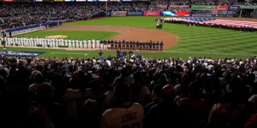 A U.S. flag covers the outfield during a baseball game.