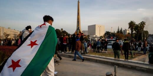 A man draped in the Syrian revolutionary flag.
