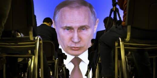 Journalists watch as Russian President Vladimir Putin gives his annual state of the nation address.
