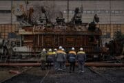 Ukrainian power plant workers inspect a voltage transformer that was destroyed after a Russian attack.