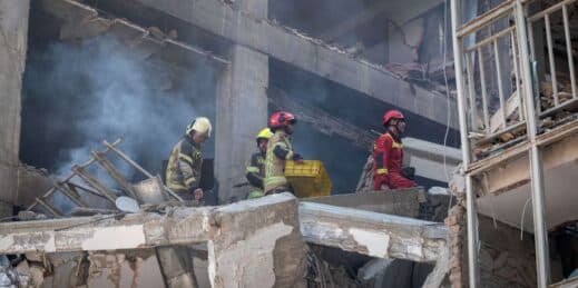Iranian firefighters work at the scene of a residential building destroyed by Israeli air strikes.