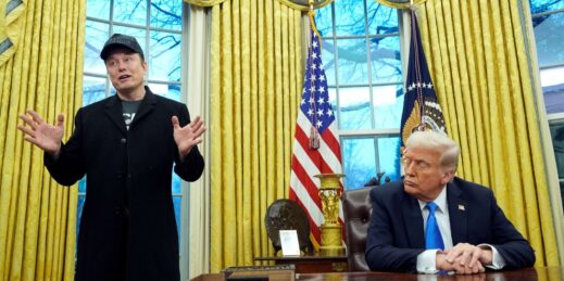 U.S. President Donald Trump listens as Elon Musk speaks.