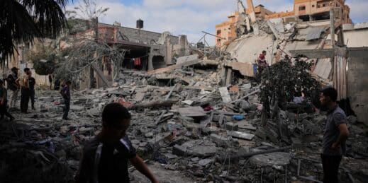 Palestinians inspect rubble.
