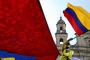 A person waving a flag at a rally in Colombia.